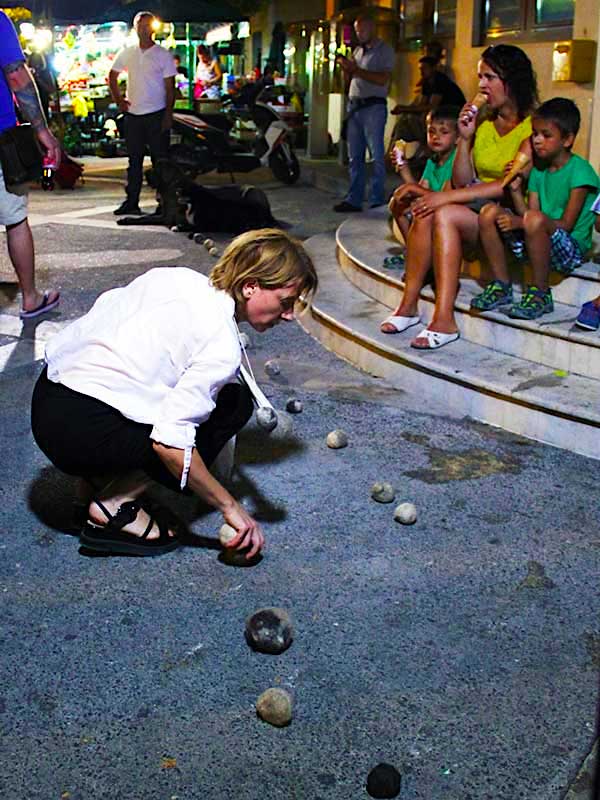 woman placing dog hair balls on street in evening