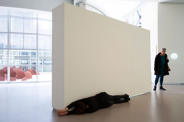 woman pressing body on white wall