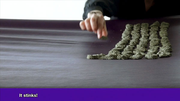 hand placing sand objects on purple sheet
